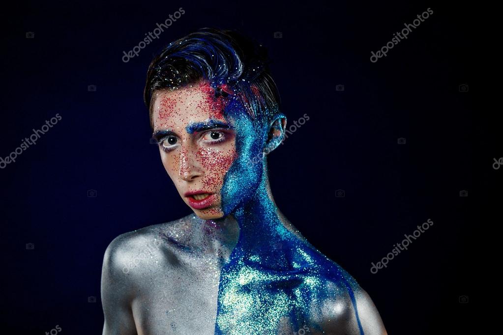 Crazy young androgyne man with face art. SPACEMAN. Freak person. Sperm on face. Tinsel creative blue makeup. Intersex and anorexia concept. Space for logo