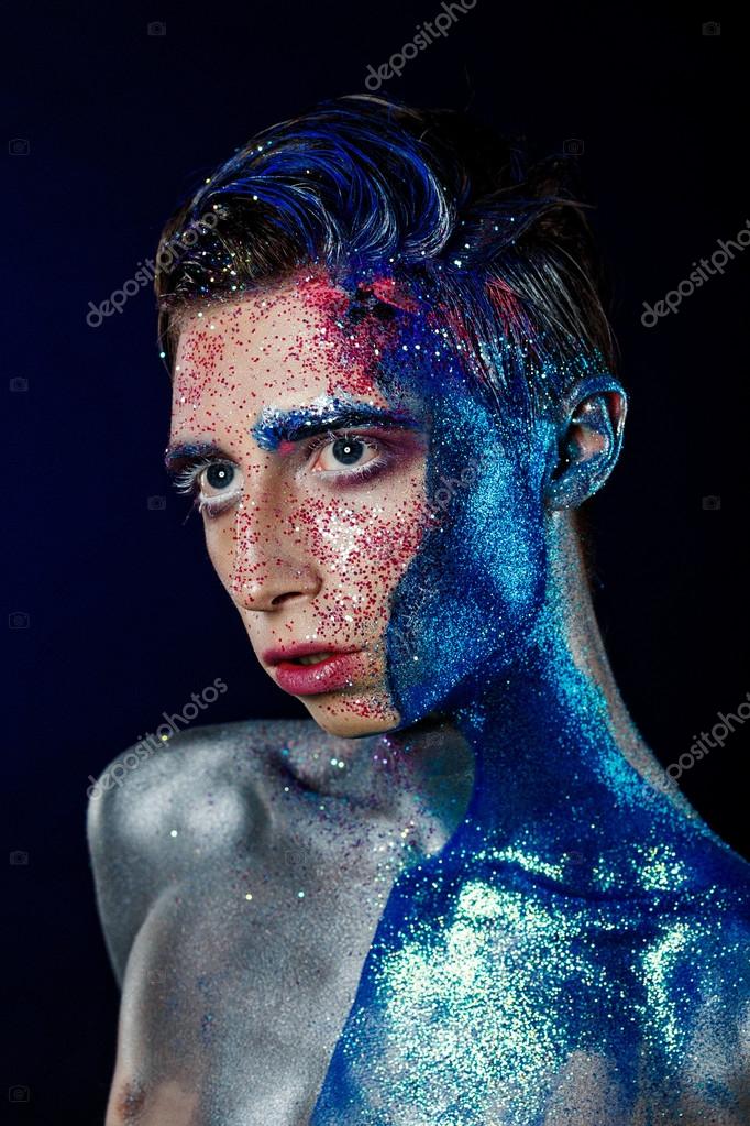 Crazy young androgyne man with face art. SPACEMAN. Freak person. Sperm on face. Tinsel creative blue makeup. Intersex and anorexia concept. Space for logo