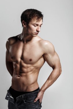 Yakışıklı atletik adam düğmesiz kot ile yan bakıyor. Stron