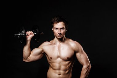 Handsome athletic man with dumbbells confidently looking forward