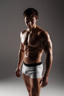 Strong Athletic Man showing muscular body and sixpack abs. Showi