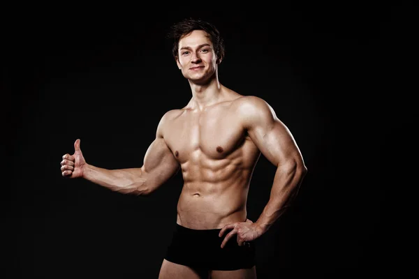 Kas ve fit genç vücut geliştirmeci fitness erkek modeli gösteren th — Stok fotoğraf