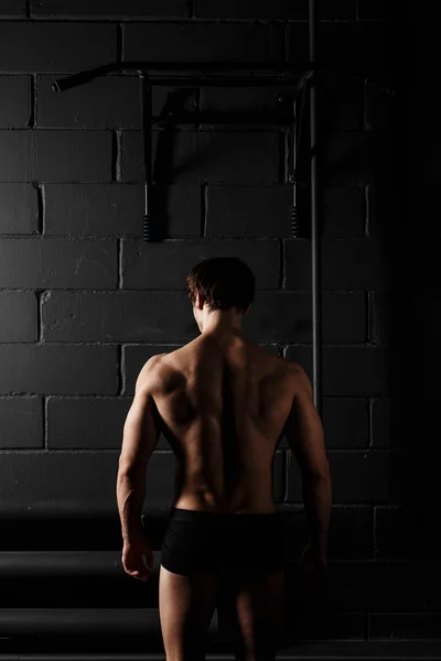 Спортсмен м'язиста фітнес-модель, що тягнеться на горизонтальну планку — стокове фото