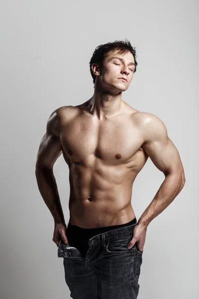 Muskulös manlig modell bodybuilder med knäppte jeans. Studio sh — Stockfoto