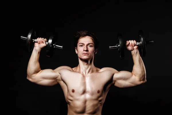 Handsome athletic man with dumbbells confidently looking forward — 스톡 사진