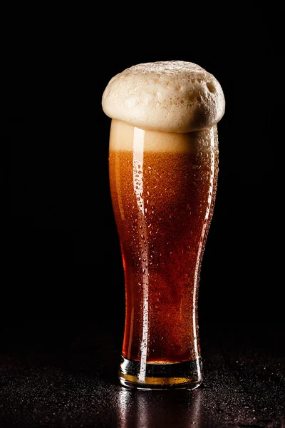 Beer Glass with DROPS on black. FRESH! MUCH FOAM! Beer bubbles c