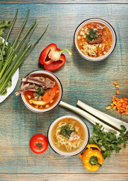 Three lagman and shurpa soups in uzbek bowls with decor and vege — Stock Image Three lagman and shurpa soups in uzbek bowls with decor and vege Royalty Free Stock Images