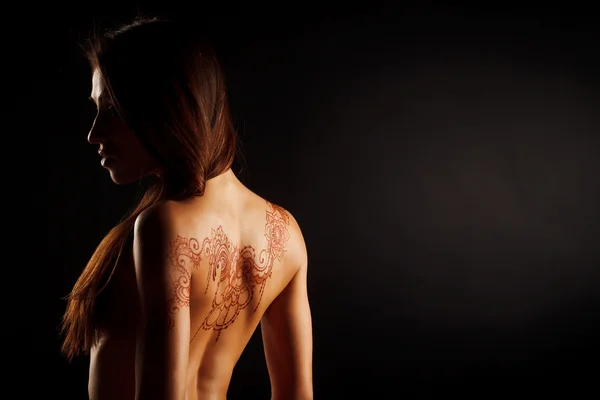 Обнаженная спина молодой девушки с татуировкой Хенны Мехенди — стоковое фото