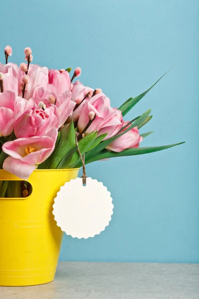 Ramo de tulipanes rosados frescos con coño-sauce en cubo amarillo — Foto de Stock