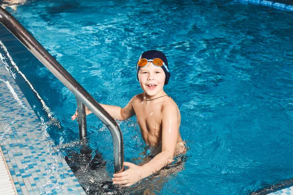 Niño usando escalera para salir de la piscina — Foto de Stock
