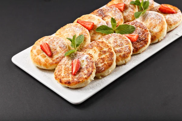 Hot tasty small cheesecakes with strawberry and mint — Stock Photo, Image