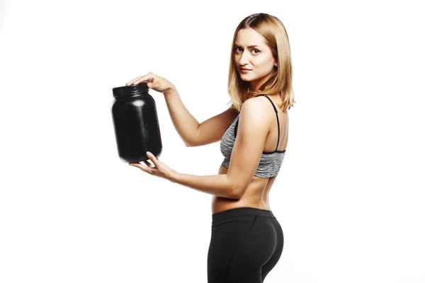 Vackra fitness tjej håller burk sport nutrition — Stockfoto