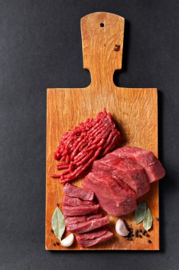 Fresh butcher cut meat assortment on black background clipart