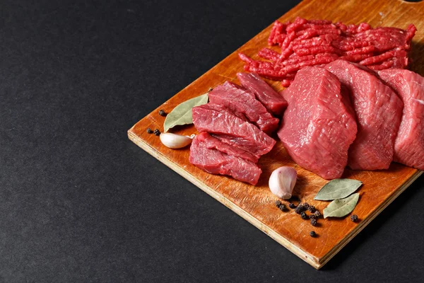 Assortiment de viande fraîche coupée de boucher sur fond noir — Photo