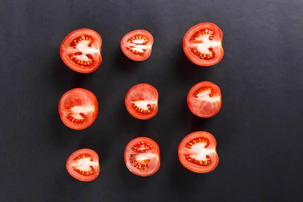 Juego de tomates cortados sobre papel negro — Foto de Stock