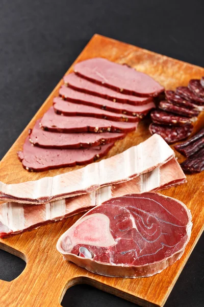 Viande de cerf et saucisse sur planche à découper — Photo