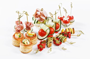 Nice set of canapes for one person with vegetables, cheese, fruits, berries, salami, seafood, meat and decoration on white background studio isolated with space for text template