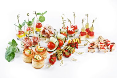 Nice set of canapes for one person with vegetables, cheese, fruits, berries, salami, seafood, meat and decoration on white background studio isolated with space for text template