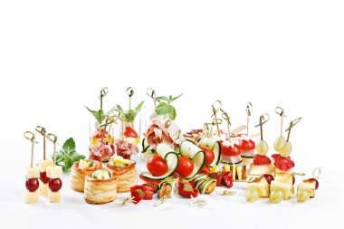 Great attractive set of canapes with vegetables, cheese, fruits, berries, salami, seafood, meat and decoration on white background studio isolated with space for text template