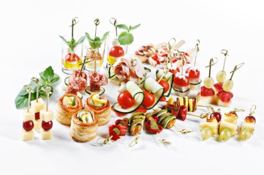 Great attractive set of canapes with vegetables, cheese, fruits, berries, salami, seafood, meat and decoration on white background studio isolated