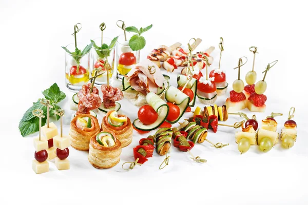 Gran conjunto atractivo de canapés con verduras, queso, frutas, bayas, salami, mariscos, carne y decoración sobre fondo blanco estudio aislado —  Fotos de Stock
