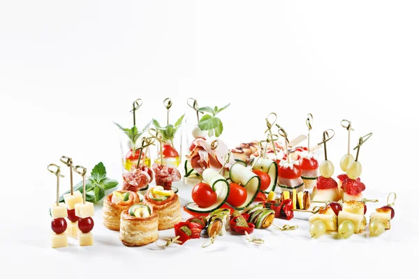 Grande conjunto atraente de canapés com legumes, queijo, frutas, bagas, salame, frutos do mar, carne e decoração no estúdio de fundo branco isolado com espaço para modelo de texto — Fotografia de Stock