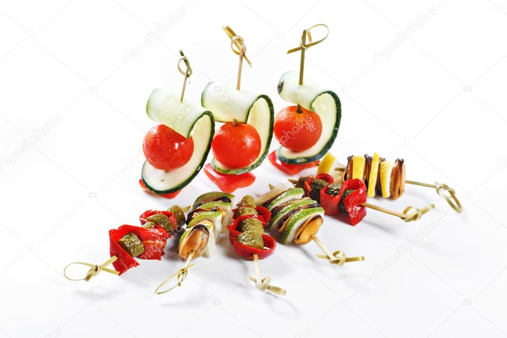 Nice set of canapes for one person with vegetables, cheese, fruits, berries, salami, seafood, meat and decoration on white background studio isolated with space for text template