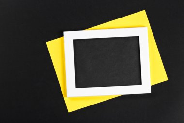 Siyah alan ve açı ile gerçek gölgeler izole siyah arka plan üzerine altında sarı kağıt yatay beyaz fotoğraf çerçevesi