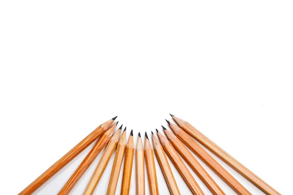 Dodici matite parallele in legno rimangono insieme su sfondo bianco. vista da vicino. immagine isolata — Foto Stock