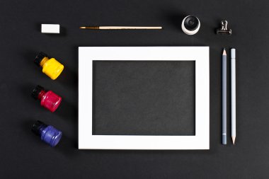 template with white photo frame on pink paper with brushes and g