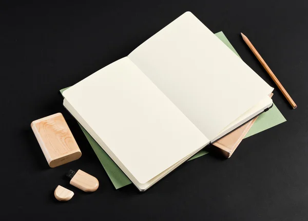 Open blank notepad with empty white pages laying above book with — ストック写真