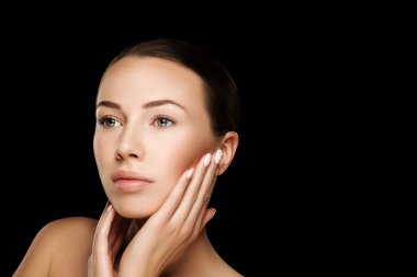 Beautiful young brunette woman with clean fresh skin with nude makeup with hands at face. Closeup real photo