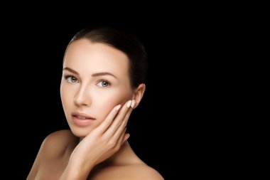 Beautiful young brunette woman with clean fresh skin with nude makeup with hands at face. Closeup real photo