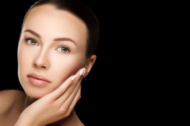 Beautiful young brunette woman with clean fresh skin with nude makeup with hands at face. Closeup real photo