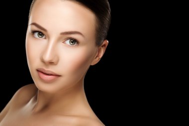 Beautiful young brunette woman with clean fresh skin with nude makeup with hands at face. Closeup real photo