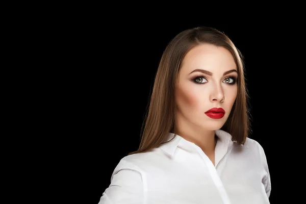 Young beautiful brunette woman with makeup and red lips in white shirt on black background — Zdjęcie stockowe