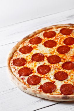 Ahşap masa üzerinde hizmet lezzetli taze salamlı pizza