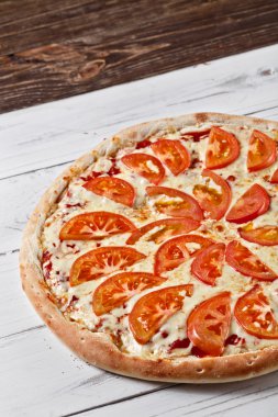 Delicious fresh pizza with tomato and cheese served on wooden ta