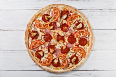 Delicious fresh pizza with chicken ham tomato served on wooden t