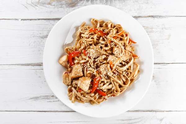 Nouilles udon frites avec poulet sur table en bois. Tampon thaï — Photo