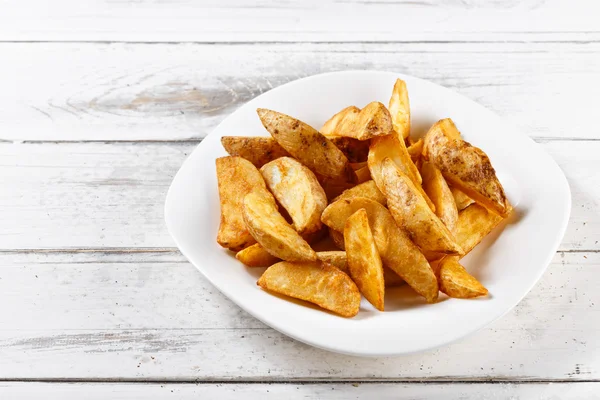 Batatas fritas fatias batatas fritas na mesa de madeira — Fotografia de Stock