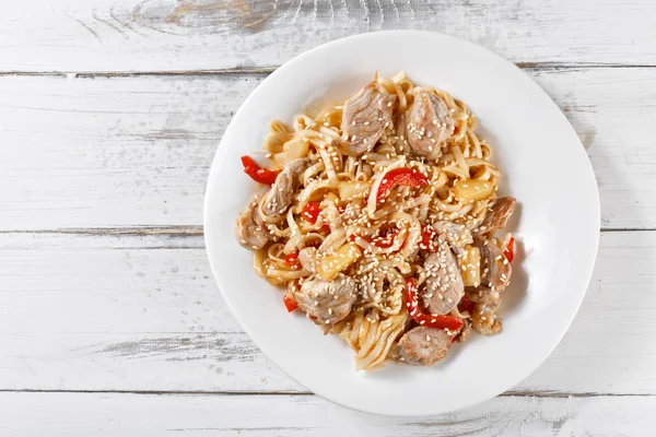 Nouilles udon frites avec porc et ananas sur table en bois. Coussinet — Photo