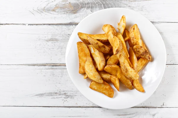 Batatas fritas fatias batatas fritas na mesa de madeira — Fotografia de Stock