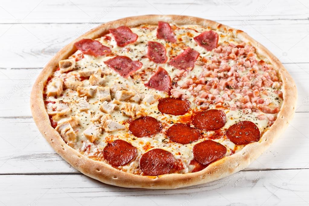 Delicious 4 in 1 fresh pizza with different kinds of meat served