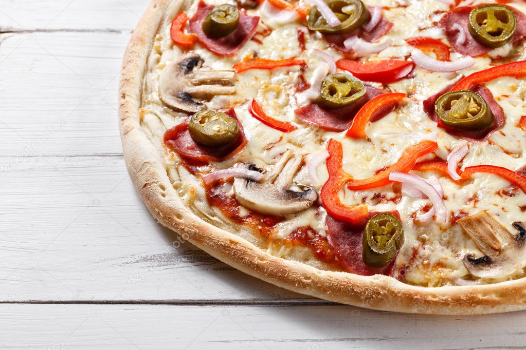 supreme spicy pizza with chili pepper served on wooden table