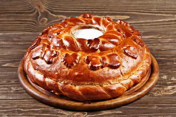 Russian wedding round loaf close-up on wooden table. Wedding bre