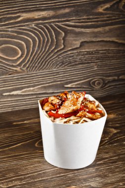 Lezzetli wok erişte udon ve ahşap masa üzerinde tavuk ile konteyner kutu. Çin ve Asya paket servisi olan restoran lokanta.