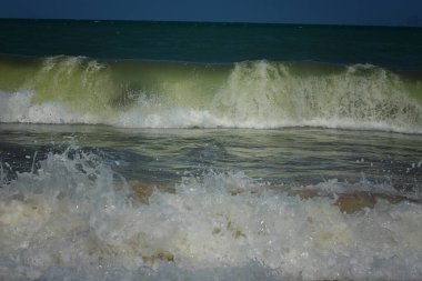 Kumlu sahilde deniz dalgaları.