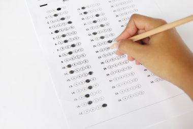 Standardized test form with answers bubbled in and a pencil, foc clipart