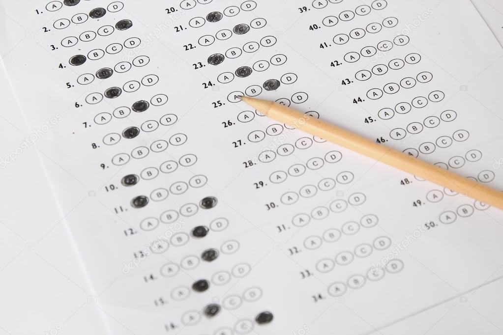 Standardized test form with answers bubbled in and a pencil, foc